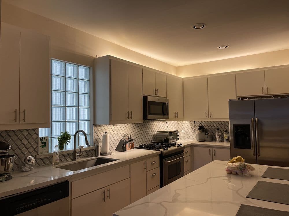White quartz countertops with diamond-pattern backsplash and under-cabinet lighting